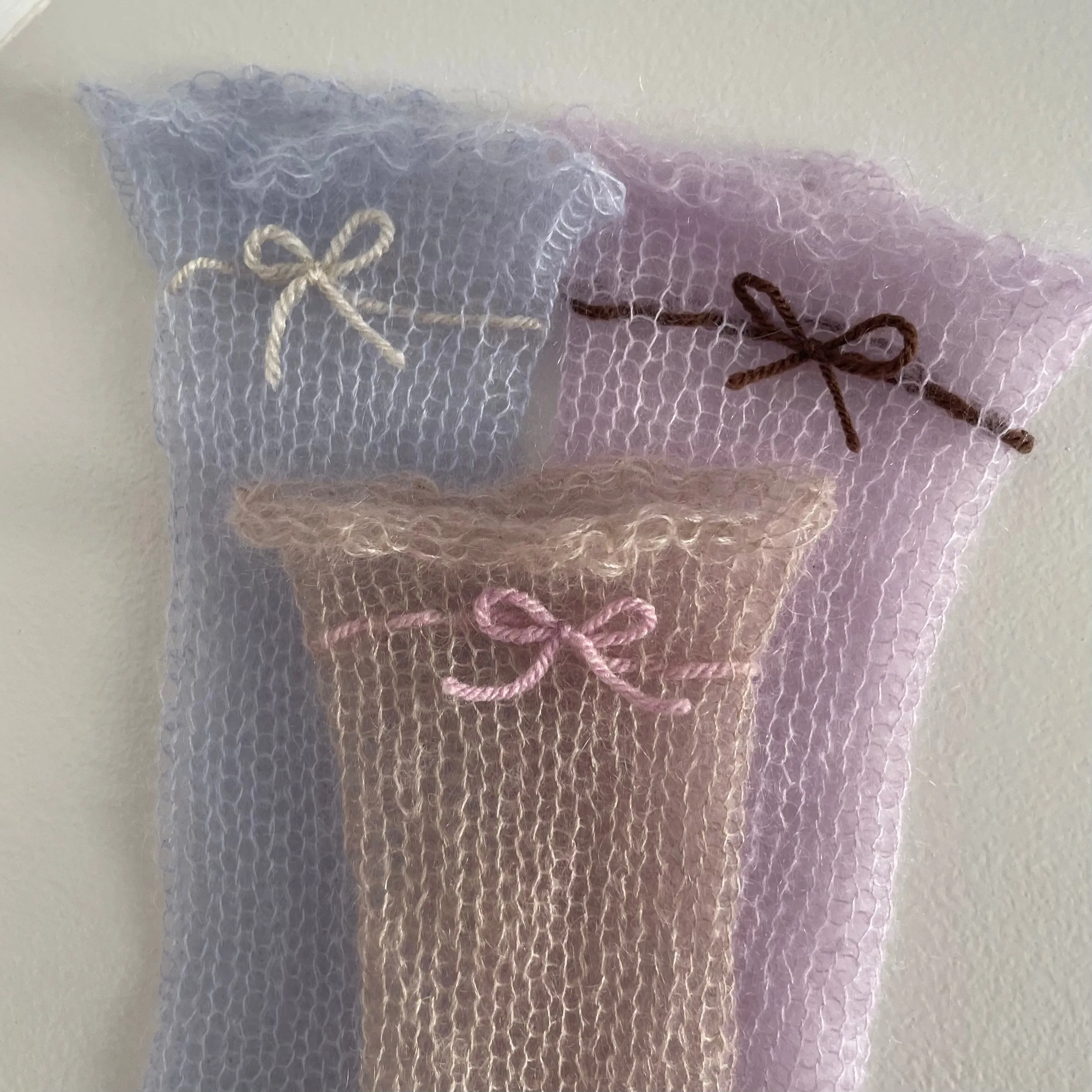 Handmade knitted mohair hand warmers in beige with dusky pink bow